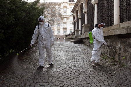 Sofia, Bulgaria - 11 April, 2020: Workers spray disinfectant outside of Sveta Nedelya Church against the spread of coronavirus disease COVID-19.のeditorial素材