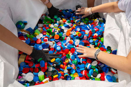 Thousands of different colourful plastic caps are being sorted for recycling.の写真素材