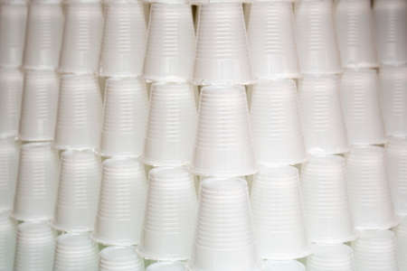 White plastic cups are seen stacked. Most disposable plastic utensils are made of polystyrene.の写真素材