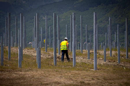 Worker walks through a future solar panels installation in a field.の写真素材