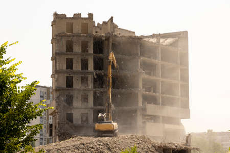 ?xcavator demolishes the reinforced concrete construction of an old building.の写真素材