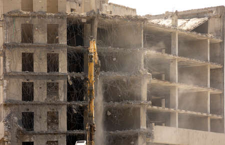 ?xcavator demolishes the reinforced concrete construction of an old building.の写真素材