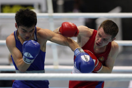 Sofia, Bulgaria - 26 February, 2021: Dorin Bucsa (red) of Moldova and Biibars Zheksen of Kazakhstan fight in their semifinal round of Feather (57kg) category of the 72-nd International Boxing Tournament "Strandja" 2021.のeditorial素材