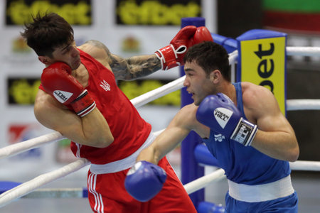 Sofia, Bulgaria - 26 February, 2021: Kots Maxim (red) of Ukraine and Dilshodbek Ruzmetov of Uzbekistan fight in their semifinal round of Light Heavy (81kg)category of the 72-nd International Boxing Tournament "Strandja" 2021.のeditorial素材