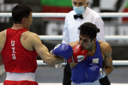 Sofia, Bulgaria - 26 February, 2021: Bobo-Usmon Baturov (red) of Uzbekistan and Naveen Boora of India fight in their semifinal round of Welter (69kg) category of the 72-nd International Boxing Tournament "Strandja" 2021.のeditorial素材