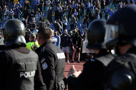 Sofia, Bulgaria: 25 April, 2021: Riot policemen stand in front of supporters after clashes during the national championship football match between Levski and CSKA Sofia. Football fans have been allowed to attend the stadium with less than 30% of the seatsのeditorial素材