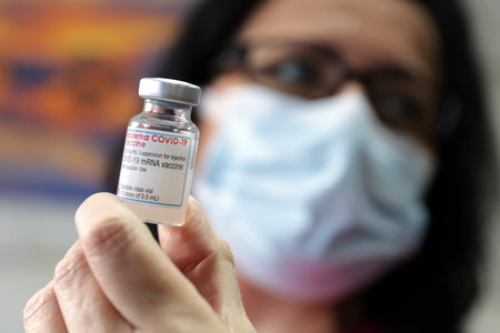 Sofia, Bulgaria - 14 January, 2021: A medical worker displays a vial of the Moderna COVID-19 vaccine at the University Obstetrics and Gynecology Hospital âMaichin Domâ before vaccinating another medical staff member.のeditorial素材