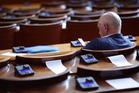 Sofia, Bulgaria - 29 July, 2021: Deputy checks his phone in the parliament plenary hall of The National Assembly of the Republic of Bulgaria before a session.のeditorial素材