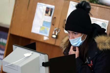 Sofia, Bulgaria: 4 April, 2021: A woman casts her ballot with a voting machine at a polling station for the parliamentary elections.のeditorial素材