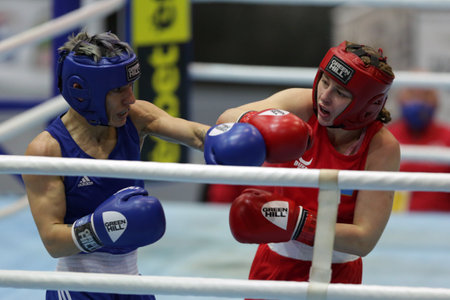 Sofia, Bulgaria - 26 February, 2021: Angelina Lukas (red) of Kazakhstan and Lacramioara Perijoc of Romania fight in their semifinal round of Fly (W51kg) category of the 72-nd International Boxing Tournament "Strandja" 2021.のeditorial素材