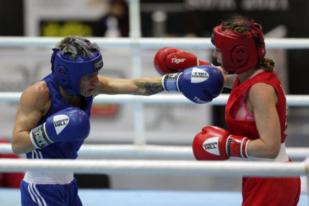 Sofia, Bulgaria - 26 February, 2021: Angelina Lukas (red) of Kazakhstan and Lacramioara Perijoc of Romania fight in their semifinal round of Fly (W51kg) category of the 72-nd International Boxing Tournament "Strandja" 2021.のeditorial素材