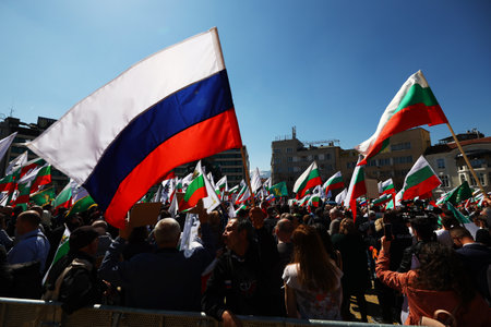 Sofia, Bulgaria - 6 April, 2022: A man waves Russian flag during an anti-government demonstration and a protest in support of Russia in front of the Bulgarian Parliament.のeditorial素材
