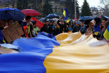 Sofia, Bulgaria - 7 April, 2022: People demonstrate holding Ukraine's national flag during a march in support of Ukraine. On 24th of February Russian army entered Ukrainian territory in what the Russian president Vladimir Putin declared a "special militarのeditorial素材