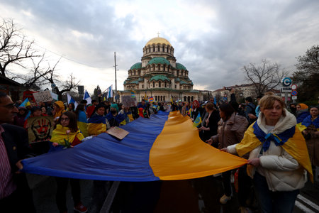 Sofia, Bulgaria - 7 April, 2022: People demonstrate holding Ukraine's national flag during a march in support of Ukraine. On 24th of February Russian army entered Ukrainian territory in what the Russian president Vladimir Putin declared a "special militarのeditorial素材