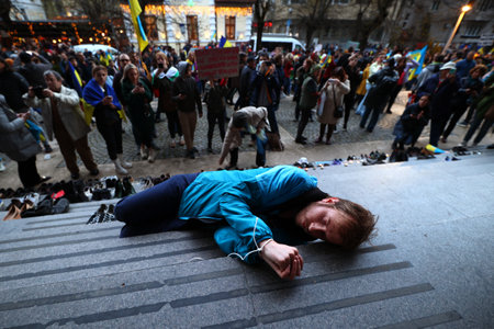 Sofia, Bulgaria - 7 April, 2022: A man with his arms tied lies on the stairs in front of the Russian cultural and information center during a demonstration in support of Ukraine. On 24th of February Russian army entered Ukrainian territory in what the Rusのeditorial素材