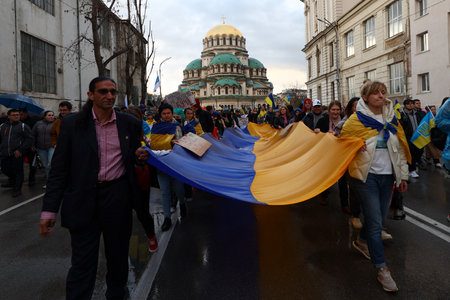 Sofia, Bulgaria - 7 April, 2022: People demonstrate holding Ukraine's national flag during a march in support of Ukraine. On 24th of February Russian army entered Ukrainian territory in what the Russian president Vladimir Putin declared a "special militarのeditorial素材
