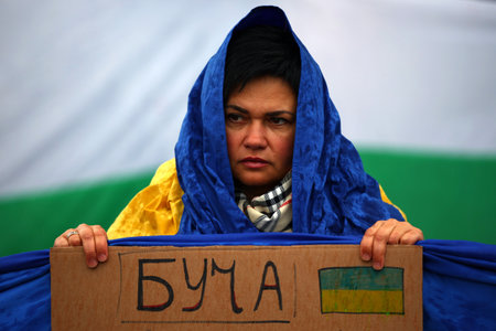 Sofia, Bulgaria - 7 April, 2022: Woman holds a sign with the name of Ukrainian city "Bucha" during a demonstration in support of Ukraine. On 24th of February Russian army entered Ukrainian territory in what the Russian president Vladimir Putin declared a のeditorial素材