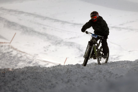 Sofia, Bulgaria - 22 January, 2022: Cyclist rides a bike downhill during an extreme snow riding mountain bicycle competition in Vitosha mountain.のeditorial素材
