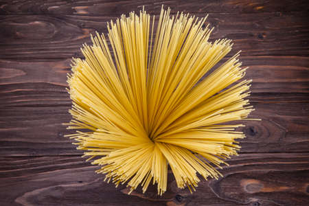Yellow long spaghetti on a rustic background, top viewの写真素材