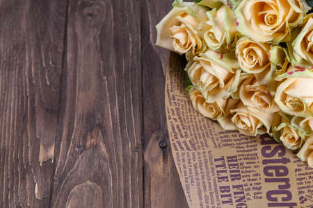 Many natural beige roses background on a wooden tableの写真素材