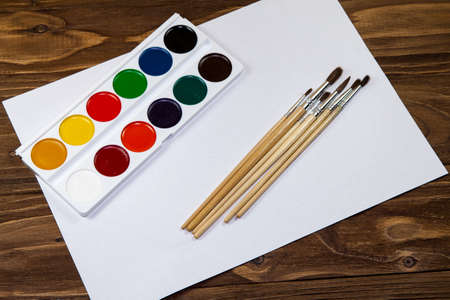 Art palette with brushes and paints on a wooden backgroundの写真素材