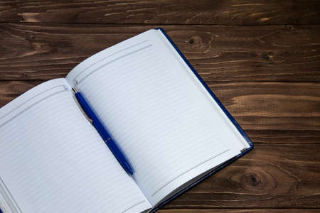 Blank notebook with pen on wooden brown table, business conceptの写真素材