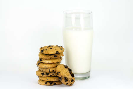 A stack of chocolate chip cookies and glass of milk on a white background.の写真素材