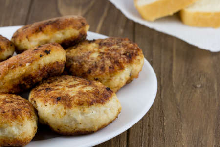 Hot meat cutlet and fresh bread on a wooden background. Close upの写真素材