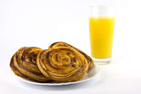 Fresh bun with raisin and orange juice isolated on a white backgroundの写真素材