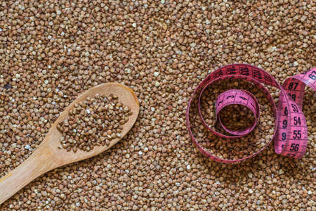Buckwheat grain, wooden spoon and centimeter or food backgroundの写真素材