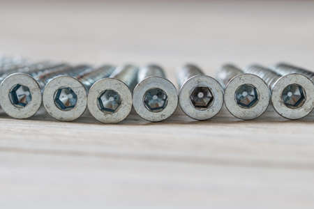 Heap of wood screw on a wooden background. Side viewの写真素材