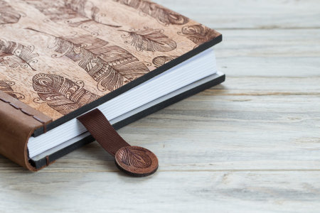 Closed blank notebook on a wooden background. Close up