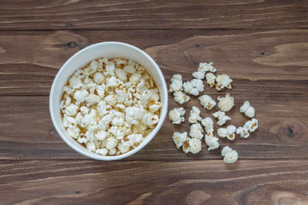 Tasty popcorn on a brown wooden backgroundの写真素材
