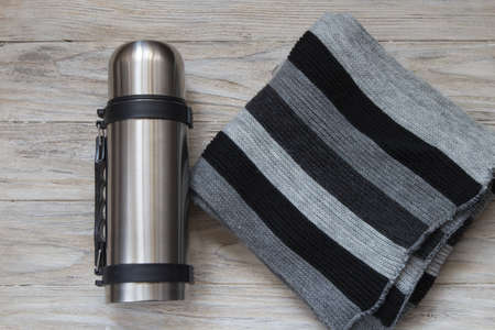 Thermos flask made of stainless steel on a woden background. Top viewの写真素材