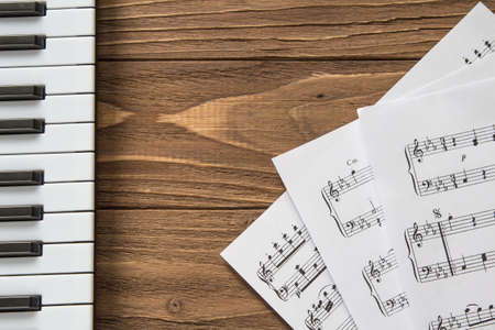 piano keyboard on wooden background with notesの写真素材