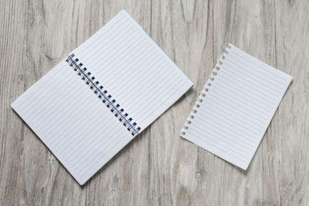 Opened notepad with a sheet of paper on wooden backgroundの写真素材