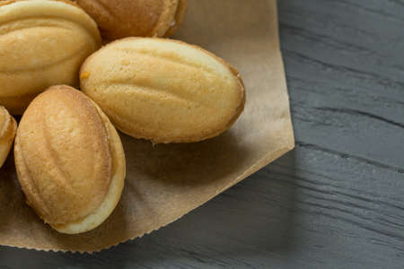 Cookies with condenced milk on cooking paper with wooden backgroundの写真素材