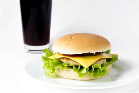 Cheeseburger on a plate and glass of cola isolated on white background, nobodyの写真素材