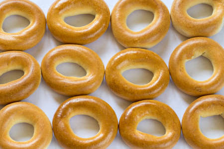 A lot of baked bagels in a raw on white background, close-upの写真素材