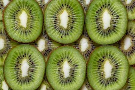 Slised pieces of kiwi background texture, top viewの写真素材