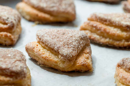 Many puff pastry cookies on white surface, close upの写真素材