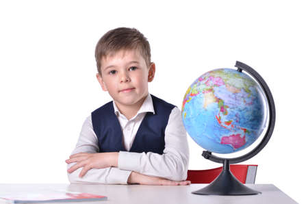 Schoolboy at the desk with a globe on itの写真素材