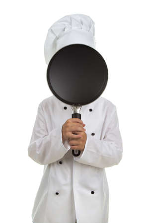 Boy chef hiding his face behind the black frying panの写真素材