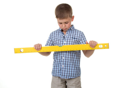 a cute thoughtful builder assistant in a blue checkered shirt holds a big yellow construction ruler