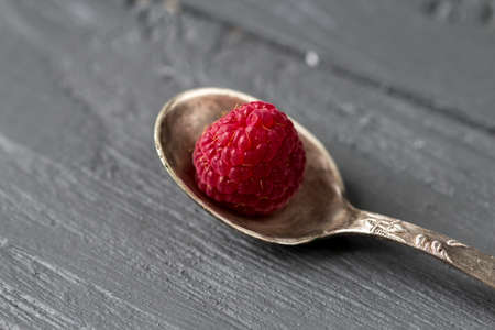 Tea spoon with appetizing fresh antioxidant raspberry on the wooden tableの写真素材