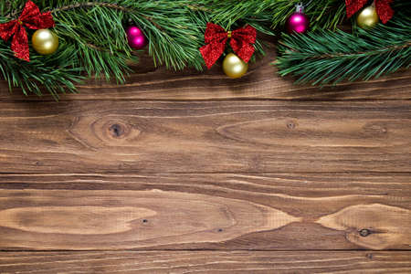 Nice christmas theme on the wooden background with pine tree branches on the top of the screenの写真素材