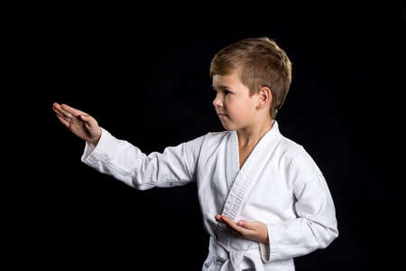 Hand hit in karate, macro. Kid in kimono on the black backgroundの写真素材