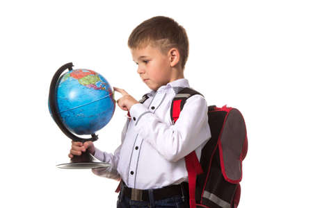 Cheerful school boy portrait with backpack, with globe, on white backgroundの写真素材