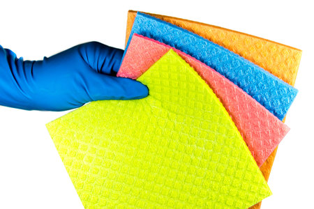 Variaty of cellulose sponge cloth in the cleaners rubber gloved hand, isolated on white background