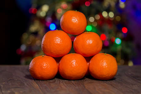 Billiard triangle composition of the tangerines on the center of the wooden table, front macroの写真素材
